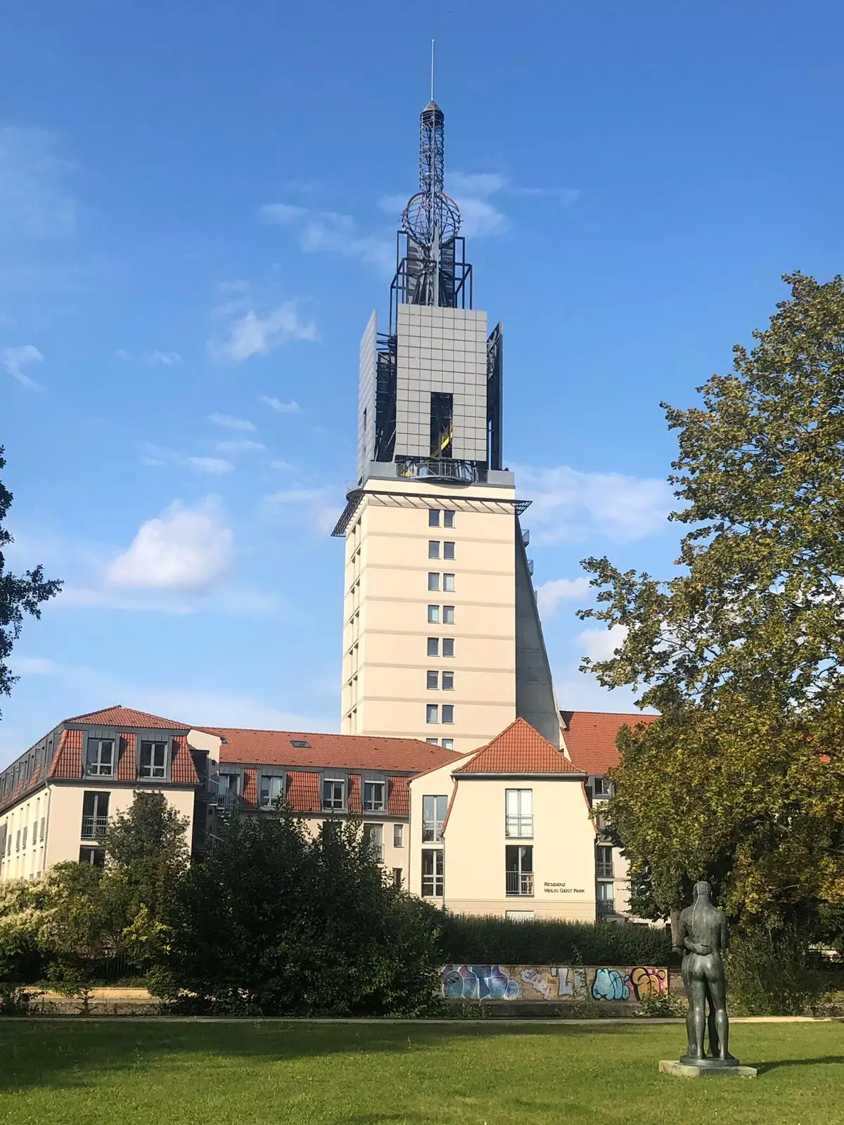 Außenansicht des Turms im Residenz Heilig-Geist-Park unter blauem Himmel.